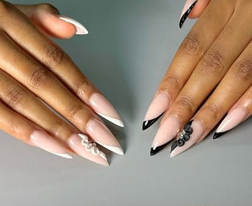 Black and white stiletto French nails with 3D flower and pearl accents by Viva Nail Spa