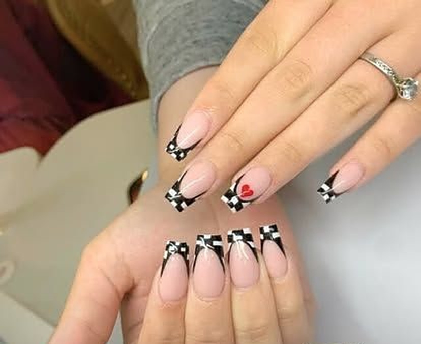 Long square French set with black and white checkerboard tips, small painted bows and one red heart accent